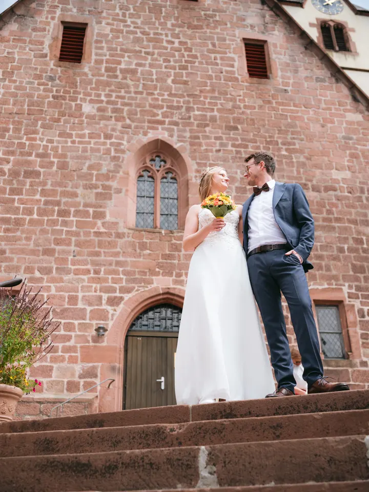 Brautpaar vor der Sandsteinfassade einer gotischen Kirche