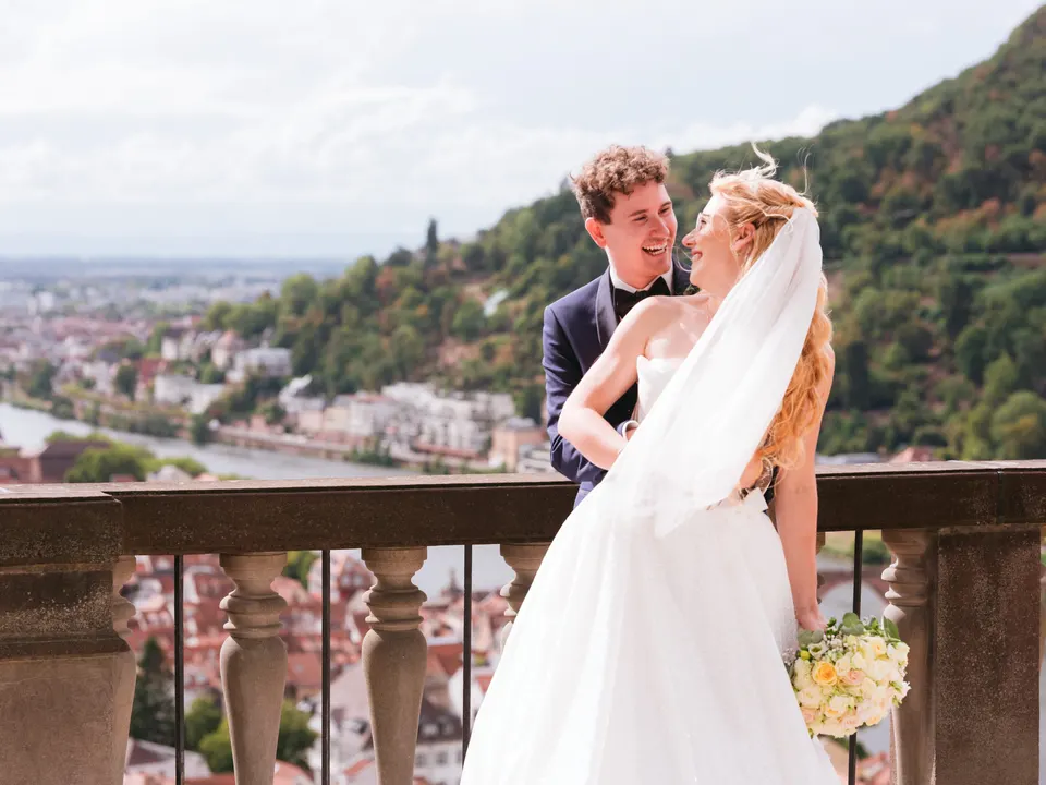 Lachendes Brautpaar auf der Schlossterrasse über Heidelberg